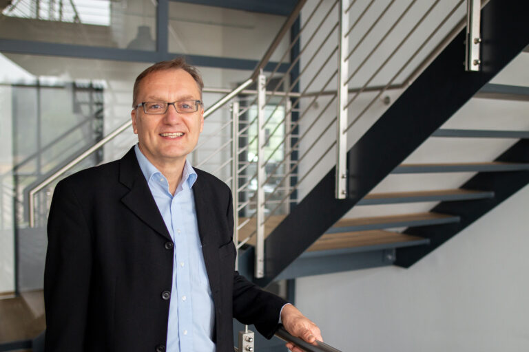 Norbert Eder, Vorstandsmitglied bei SWS Digital, vor einer Treppe